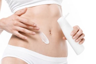 Woman applying body cream  clipart