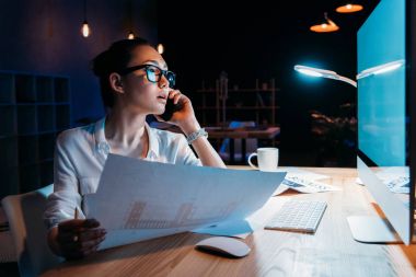 Businesswoman working late in office  clipart