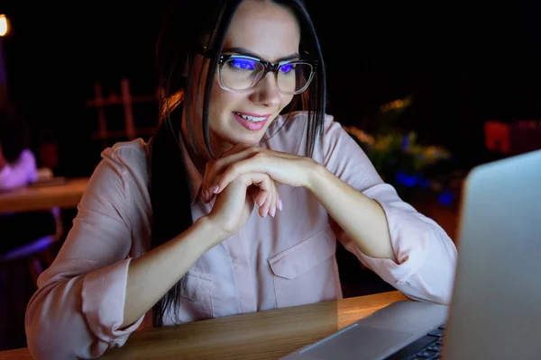Улыбающаяся деловая женщина в очках, глядя на ноутбук — стоковое фото