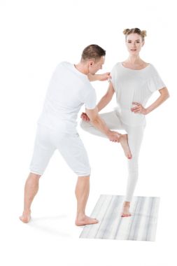 woman practicing yoga with trainer clipart