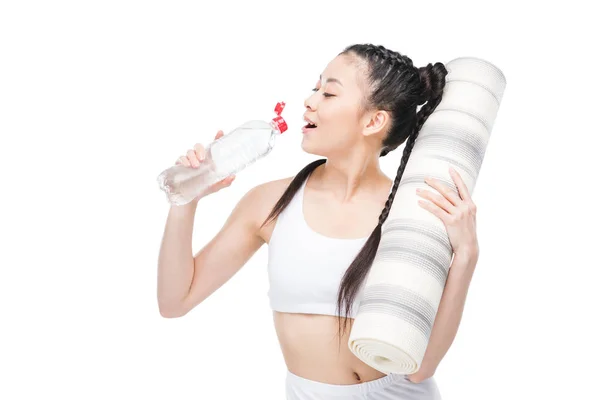 Girl with yoga mat drinking water — Stock Photo, Image