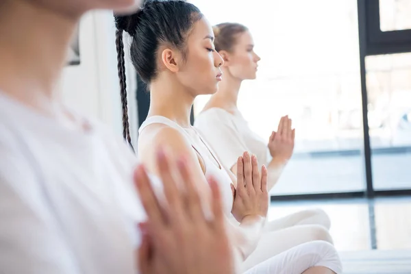 Unga kvinnor mediterar i lotus pose — Stockfoto