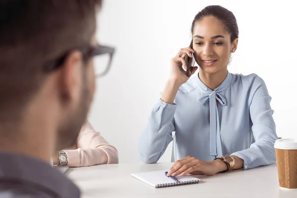 Mujer de negocios hablando en el teléfono inteligente mientras el hombre espera — Foto de Stock