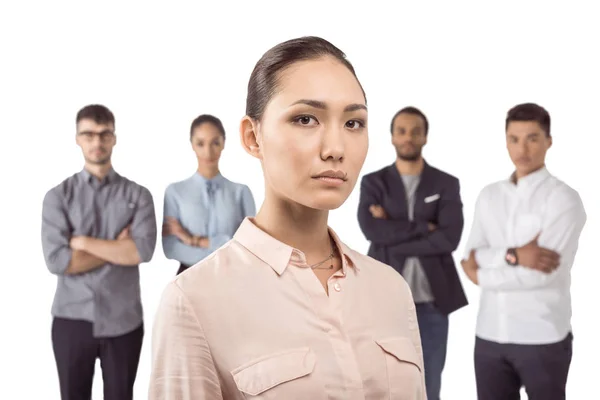 Mujer de negocios de pie delante de sus colegas — Foto de Stock