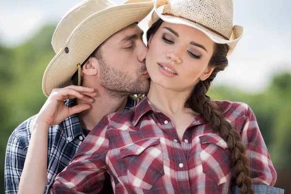 Jonge cowboy zijn sensuele vriendin zoenen — Stockfoto