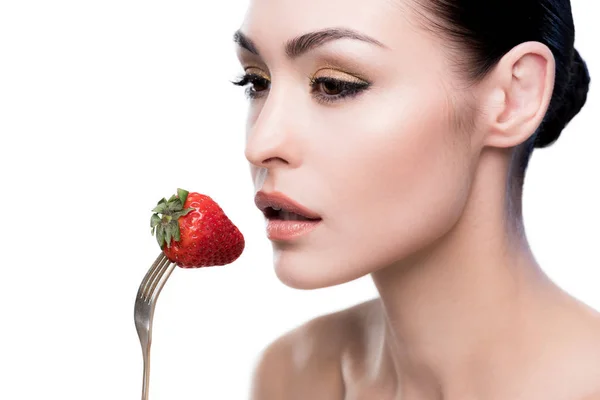 Femeie tânără care mănâncă căpșuni pe furculiță — Fotografie, imagine de stoc