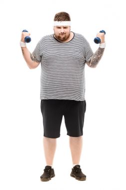young chubby man exercising with dumbbells clipart