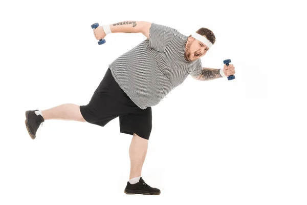 Молодий жирний чоловік біжить з гантелями — стокове фото
