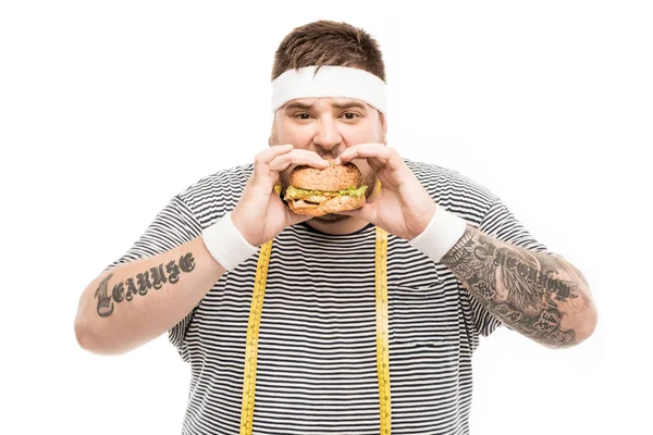 Пухлый мужчина ест гамбургер — стоковое фото