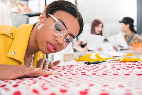 African american dressmaker fitting fabric — Stock Photo, Image