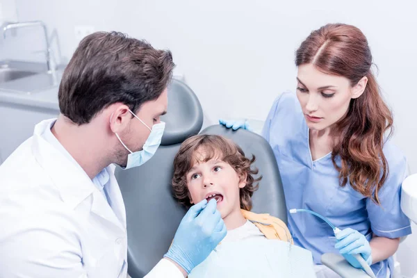 Стоматологи, осматривающие зубы пациентов — стоковое фото