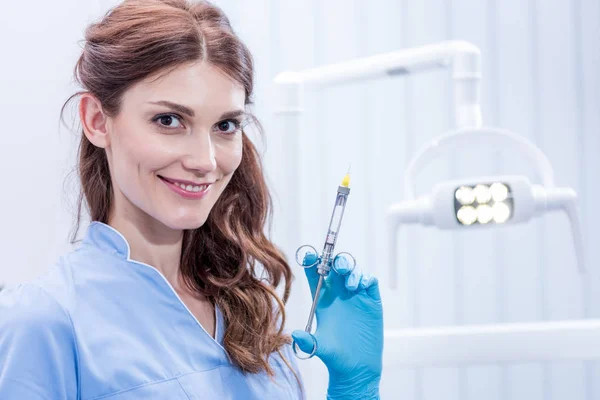 Стоматолог с зубным шприцем — стоковое фото