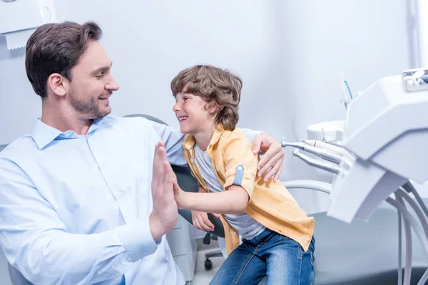 Dentist and boy in dental clinic — Stock Photo, Image
