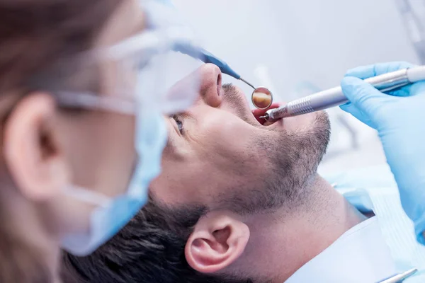 Стоматолог, лечащий зубы пациентов — стоковое фото