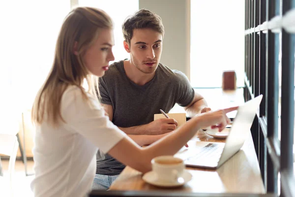 Coppia che lavora su computer portatile in caffè — Foto Stock