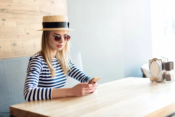 Vrouw met smartphone in cafe — Stockfoto