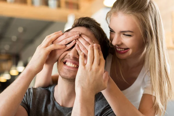 Kvinna som täcker pojkvänner ögon med händerna — Stockfoto