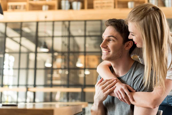 Vrouw knuffelen man in café — Stockfoto