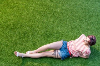 young woman resting on grass clipart