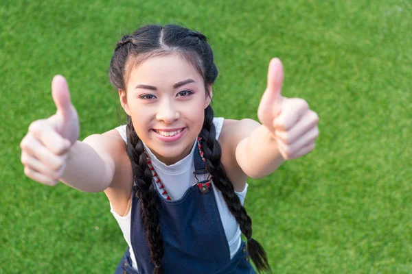 Menina asiática mostrando polegares para cima — Fotos gratuitas
