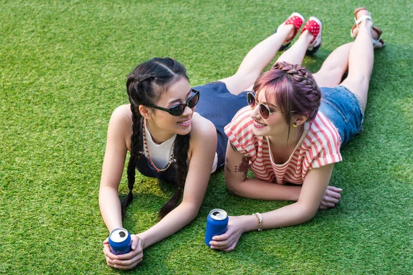 Meninas multiétnicas com latas de refrigerante — Fotografia de Stock