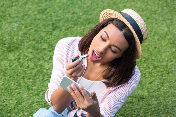 Menina afro-americana aplicando maquiagem — Fotografia de Stock