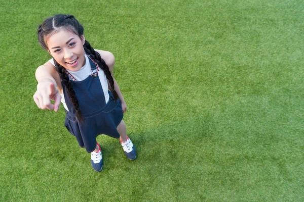 Asiatisk flicka pekar på kamera — Gratis stockfoto
