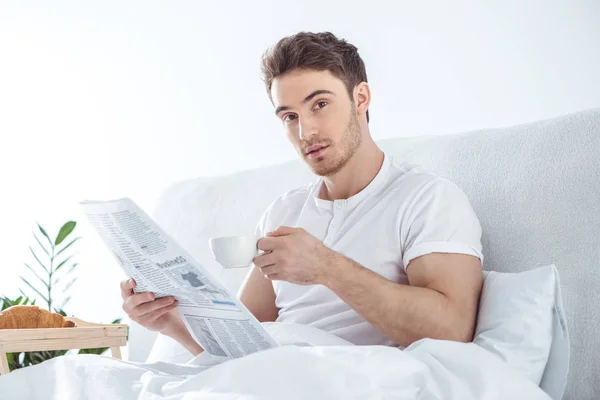 Man met krant in bed — Gratis stockfoto