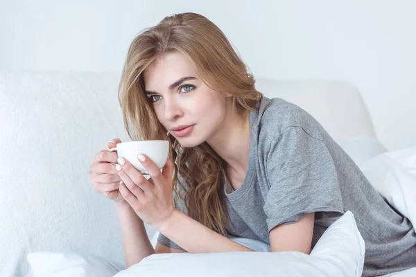 Γυναίκα με καφέ στο κρεβάτι — Φωτογραφία Αρχείου