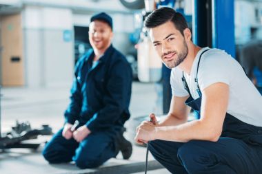 Automechanics sitting on floor clipart