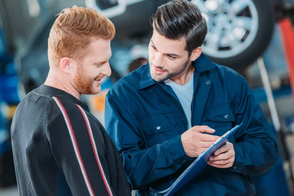 Automecânico mostrando área de transferência do cliente — Fotografia de Stock