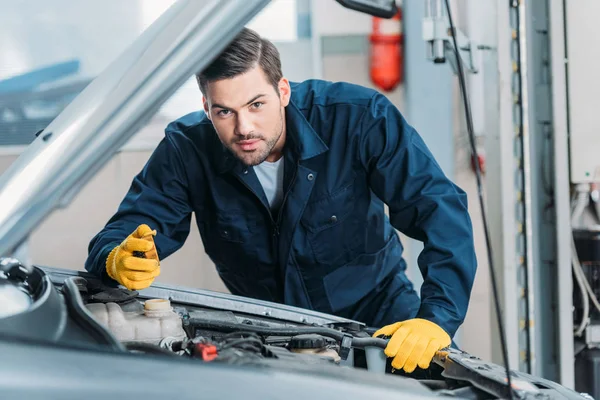 Automechanic looking under car hood — Stock Photo, Image