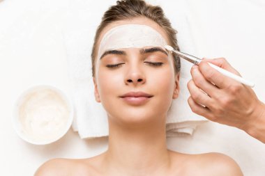 cosmetologist applying facial mask clipart