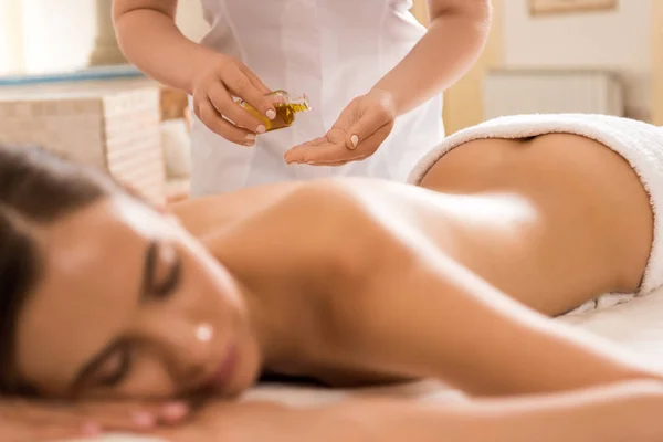 Terapeuta de massagem com óleo corporal — Fotografia de Stock