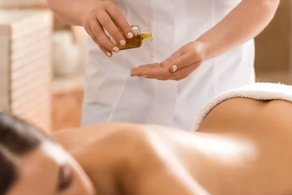 Massage therapist with body oil — Stock Photo, Image