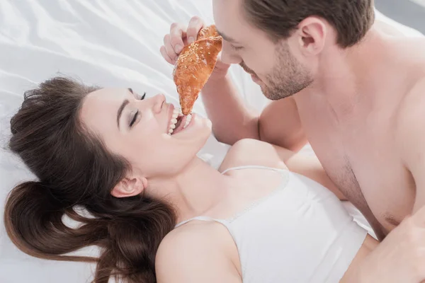 Ember etetés barátnője az ágyban — Stock Fotó