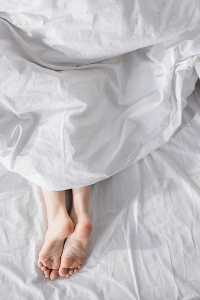 Female feet stretching out of blanket — Stock Photo, Image