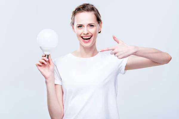 Woman pointing at light bulb — Stock Photo, Image