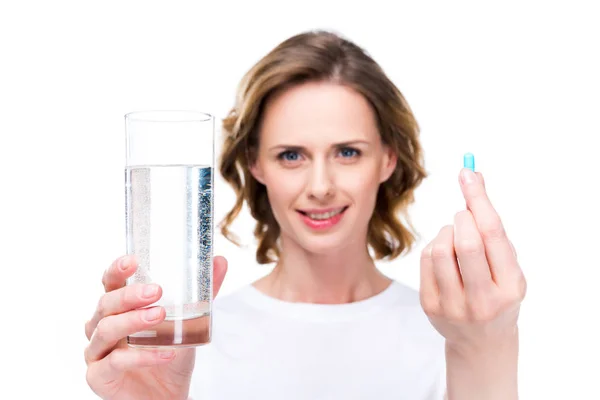 Glass of water and pill — Free Stock Photo