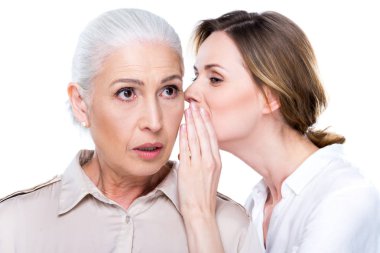 adult daughter whispering to senior mother clipart