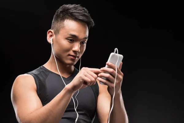 Man in earphones using smartphone — Stock Photo, Image