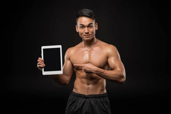 Мускулистый человек с цифровым планшетом — стоковое фото