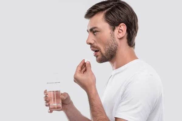 Hombre con medicamentos y vaso de agua — Foto de Stock