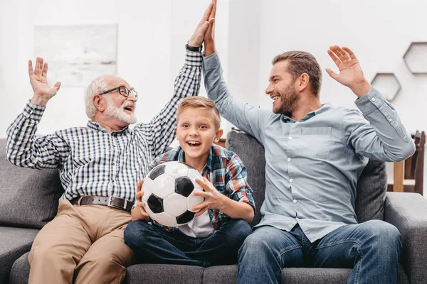 Liten pojke och familj titta på fotboll — Stockfoto