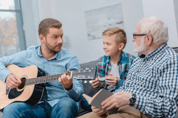Jovem pai tocando guitarra com a família — Fotografia de Stock