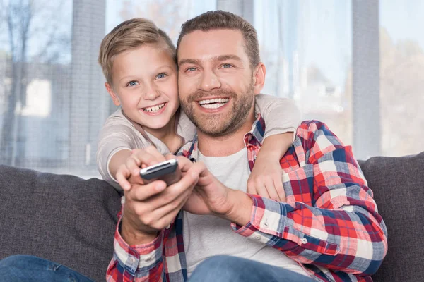 Far och son tittar på tv — Stockfoto