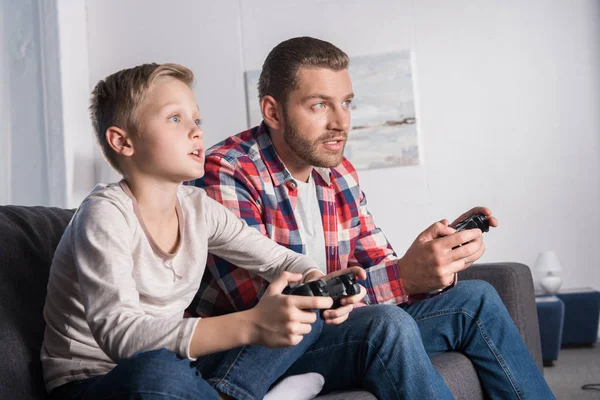Far och son leker med joysticks — Stockfoto