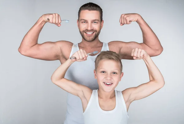 Padre e hijo mostrando bíceps — Foto de Stock