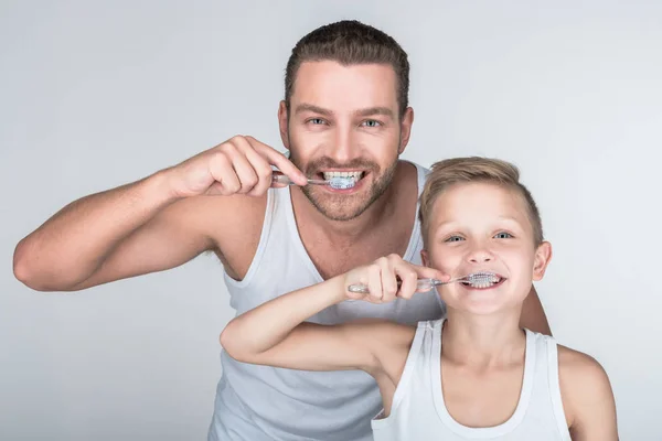 Pai e filho escovando os dentes — Fotografia de Stock