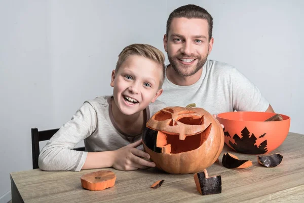Отец и сын с тыквой на Хэллоуин — Бесплатное стоковое фото
